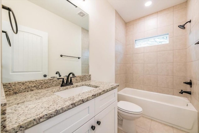 full bathroom with tiled shower / bath, vanity, tile patterned floors, and toilet