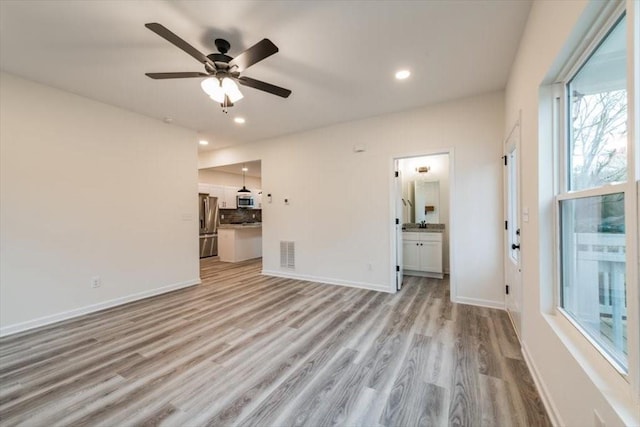 unfurnished living room with light hardwood / wood-style floors and ceiling fan