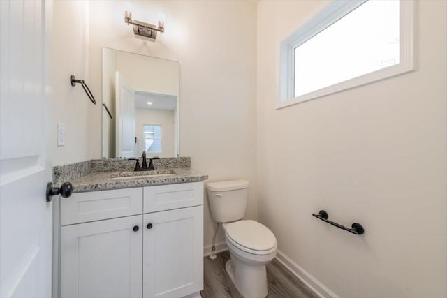 bathroom with hardwood / wood-style flooring, vanity, and toilet