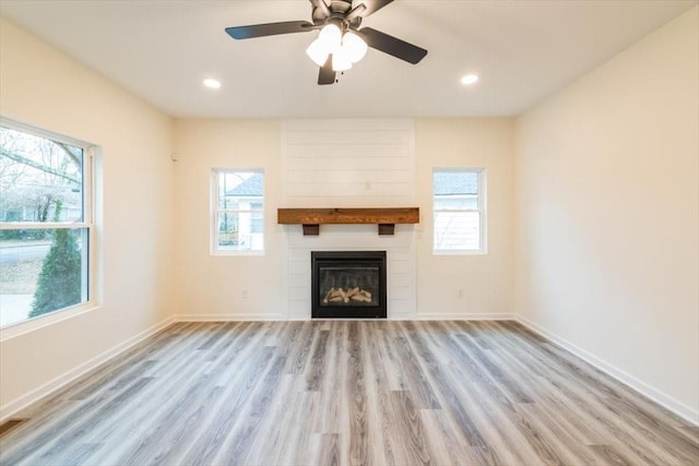 unfurnished living room with plenty of natural light, a fireplace, and light hardwood / wood-style floors