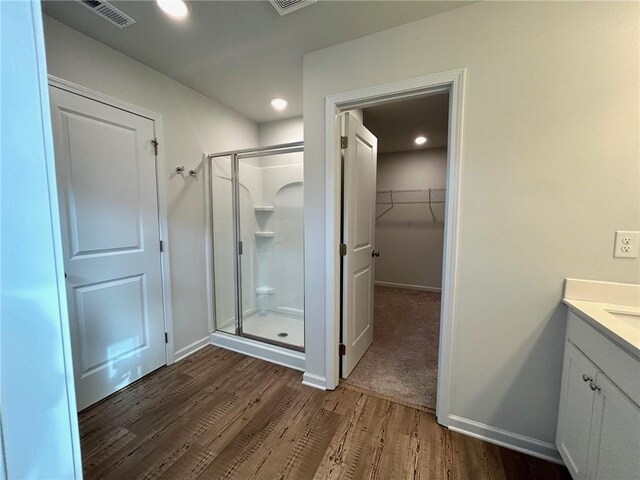 135 Softwood Ct, Dawsonville, GA 30534 - bathroom featuring a shower stall, wood finished floors, vanity, a walk in closet, and recessed lighting