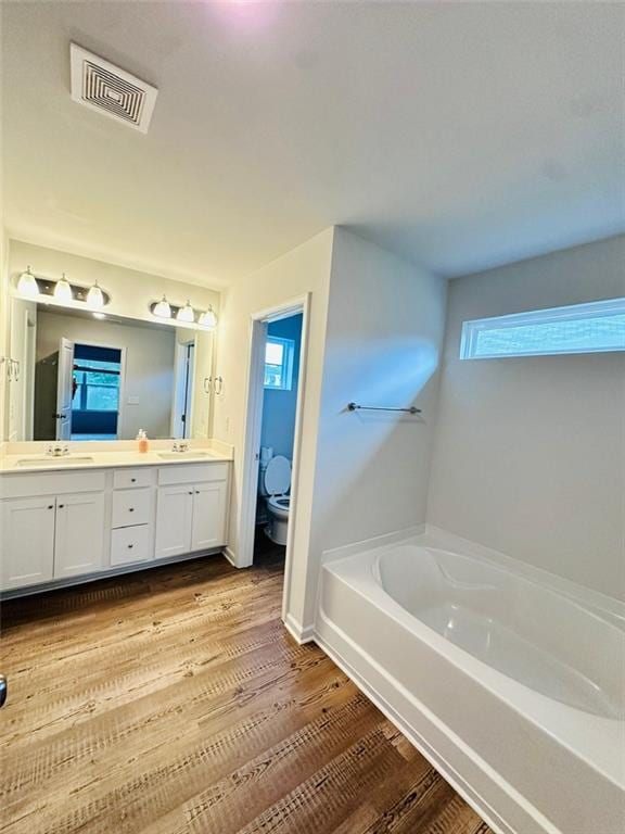 135 Softwood Ct, Dawsonville, GA 30534 - bathroom featuring a bath, double vanity, and wood finished floors