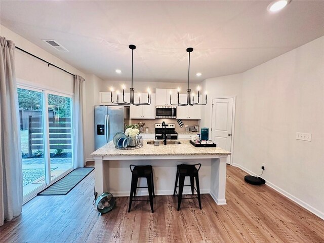 135 Softwood Ct, Dawsonville, GA 30534 - kitchen featuring appliances with stainless steel finishes, a chandelier, light wood-type flooring, white cabinets, and recessed lighting