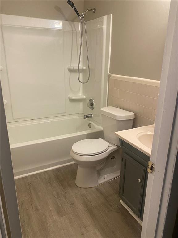 full bathroom with vanity, washtub / shower combination, hardwood / wood-style flooring, and toilet