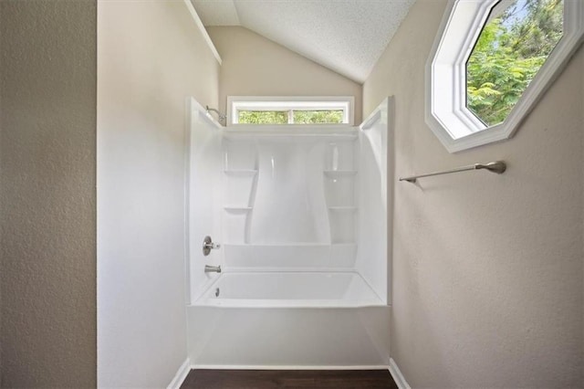 3915 Cypress Pointe Dr, Union City, GA 30291 - full bathroom featuring shower / bath combination, lofted ceiling, healthy amount of natural light, wood finished floors, and a textured wall