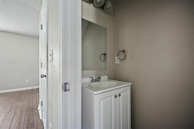3915 Cypress Pointe Dr, Union City, GA 30291 - bathroom featuring vanity, wood finished floors, a textured ceiling, and baseboards