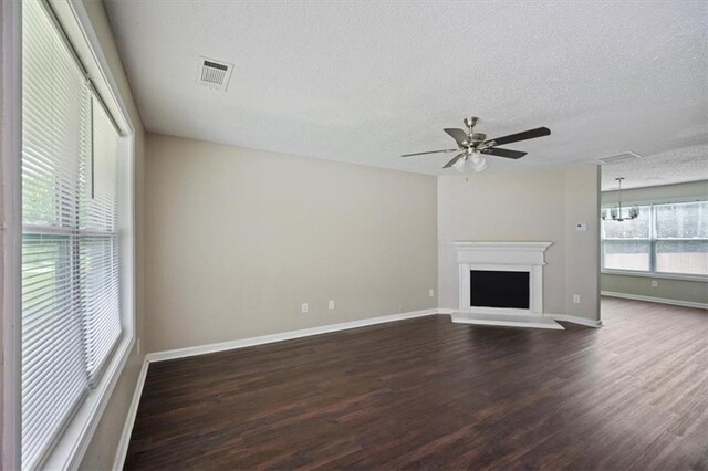 3915 Cypress Pointe Dr, Union City, GA 30291 - unfurnished living room featuring dark wood-style flooring, baseboards, a textured ceiling, ceiling fan, and a fireplace with raised hearth
