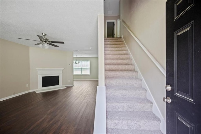 3915 Cypress Pointe Dr, Union City, GA 30291 - staircase featuring wood finished floors, ceiling fan, a fireplace with raised hearth, baseboards, and a textured ceiling