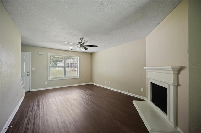 3915 Cypress Pointe Dr, Union City, GA 30291 - unfurnished living room featuring dark wood finished floors, a textured ceiling, ceiling fan, a fireplace with raised hearth, and baseboards