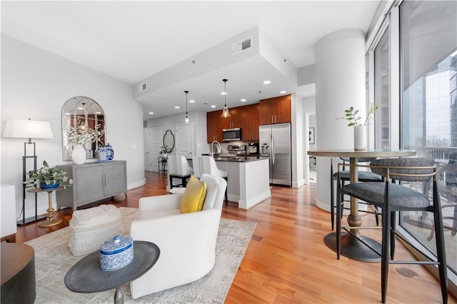 living room with sink and light wood-type flooring