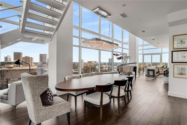 45 Ivan Allen Jr Blvd NW Unit 2705, Atlanta, GA 30308 - dining space featuring plenty of natural light, a view of city, expansive windows, a towering ceiling, and wood finished floors