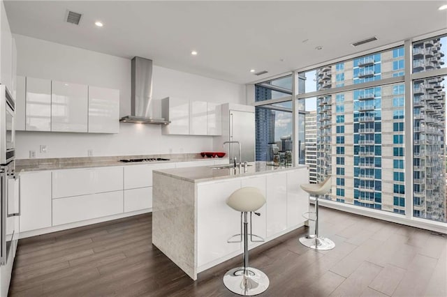 45 Ivan Allen Jr Blvd NW Unit 2705, Atlanta, GA 30308 - kitchen featuring modern cabinets, wall chimney range hood, dark wood-type flooring, black stovetop, and a sink