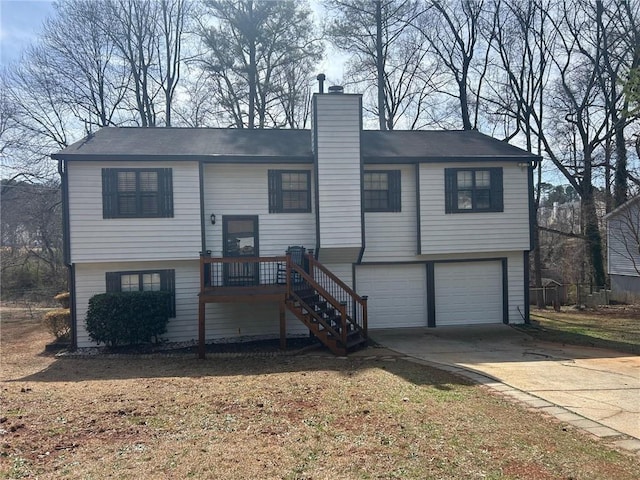 split foyer home with concrete driveway, stairway, a garage, and a chimney