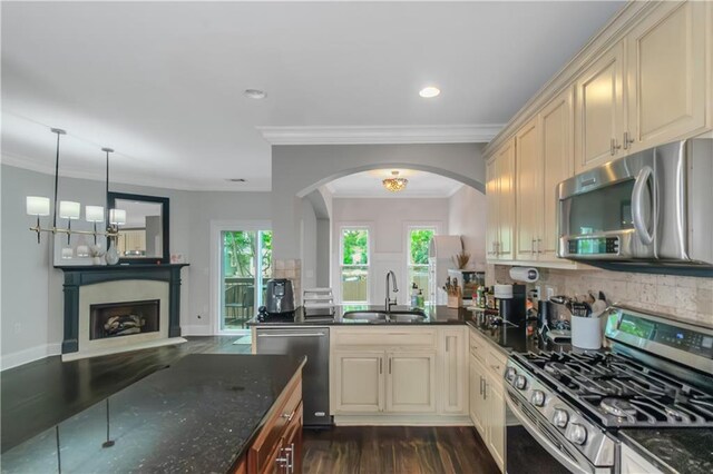 1786 Dekalb Ave NE, Atlanta, GA 30307 - kitchen featuring stainless steel appliances, a sink, cream cabinetry, a fireplace, and arched walkways