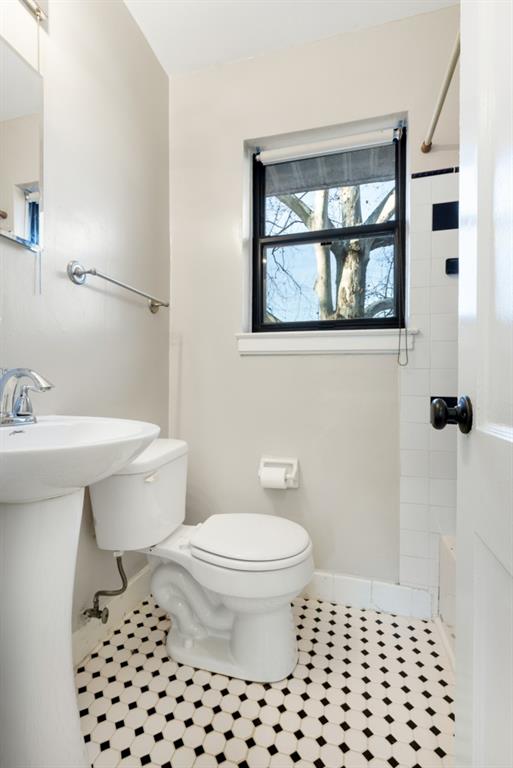 bathroom with tiled shower / bath, tile patterned floors, and toilet