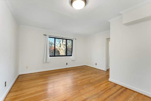 spare room with ornamental molding and light wood-type flooring