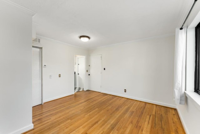 empty room featuring crown molding and light wood-type flooring