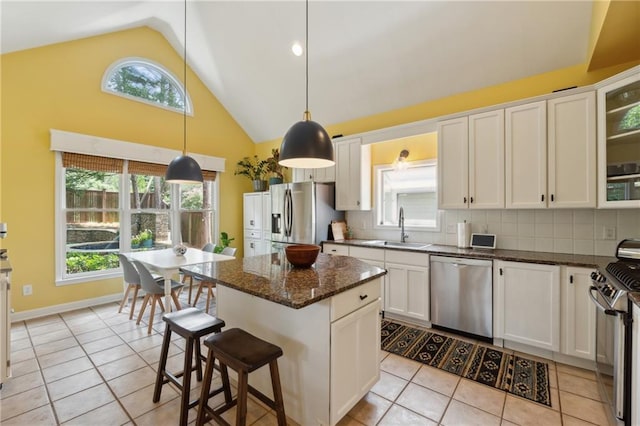 kitchen featuring a center island, sink, decorative backsplash, white cabinetry, and stainless steel appliances