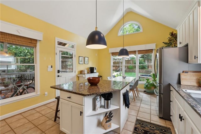 kitchen with white cabinets, light tile patterned floors, a center island, and hanging light fixtures