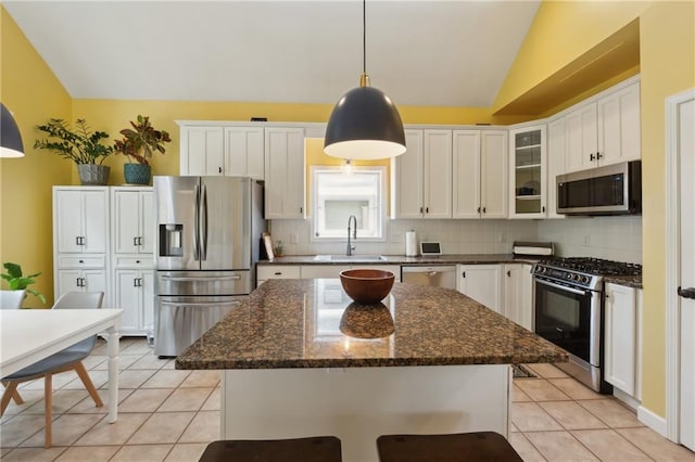 kitchen with a center island, stainless steel appliances, lofted ceiling, and sink