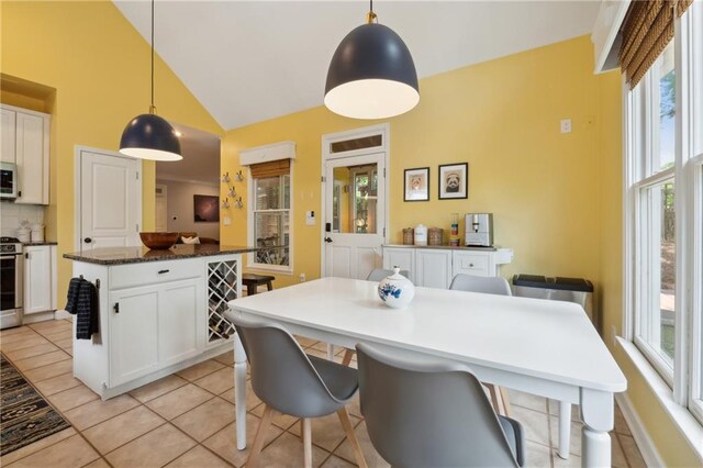 interior space with light tile patterned floors and high vaulted ceiling