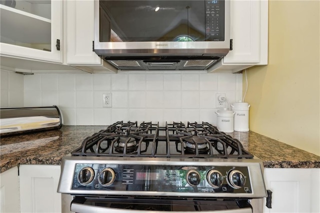 details with white cabinets, decorative backsplash, dark stone countertops, and range