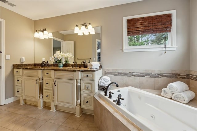 bathroom with tile patterned floors, vanity, and a relaxing tiled tub