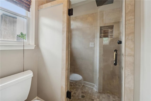 bathroom with toilet and a shower with door