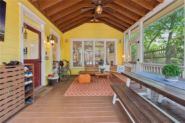 sunroom / solarium featuring lofted ceiling with beams, ceiling fan, and wood ceiling