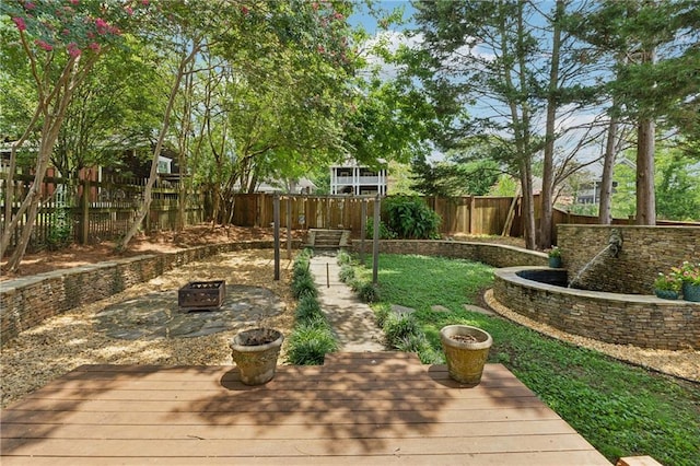 view of yard with a wooden deck and a fire pit