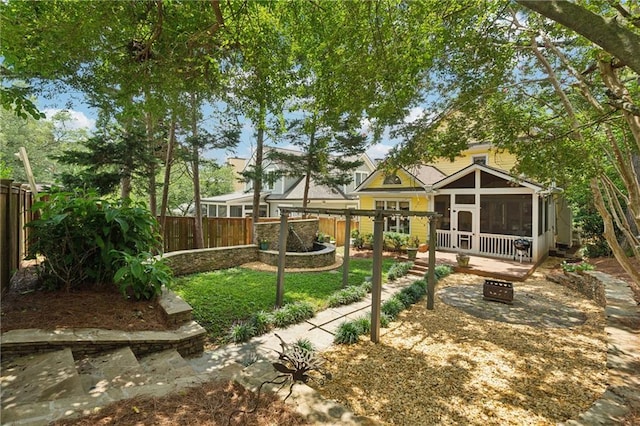 view of yard with an outdoor fire pit and a sunroom