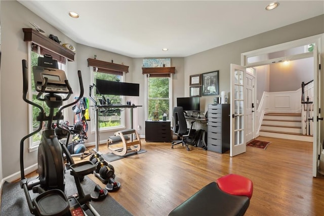 exercise area featuring french doors and light wood-type flooring