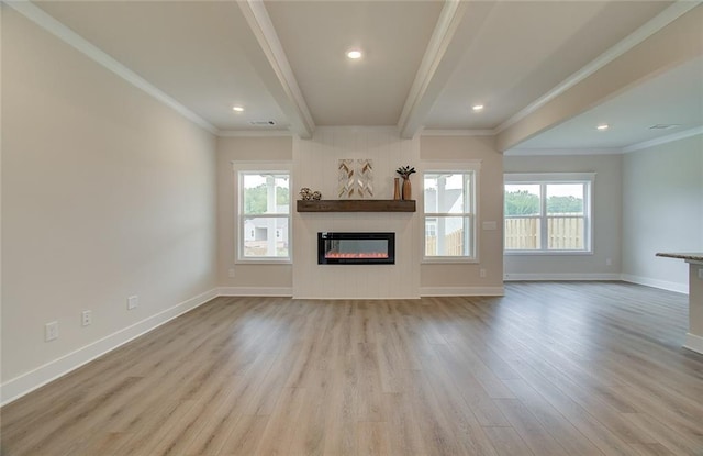 unfurnished living room featuring baseboards, ornamental molding, beam ceiling, wood finished floors, and a glass covered fireplace