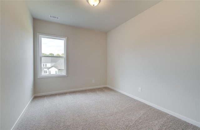 unfurnished room featuring baseboards, visible vents, and light carpet