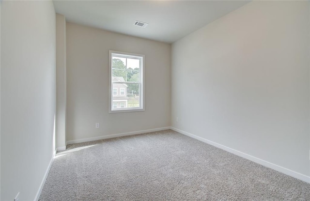 carpeted empty room with visible vents and baseboards