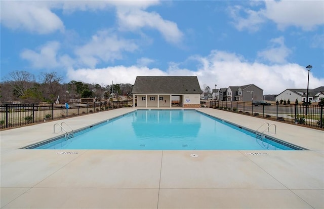 community pool featuring a residential view, a patio, and fence