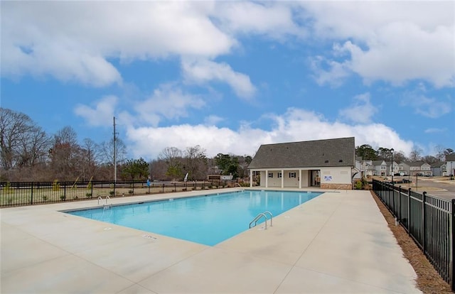 pool with a patio area and fence