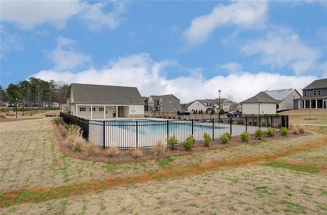 pool with a patio, fence, and a residential view