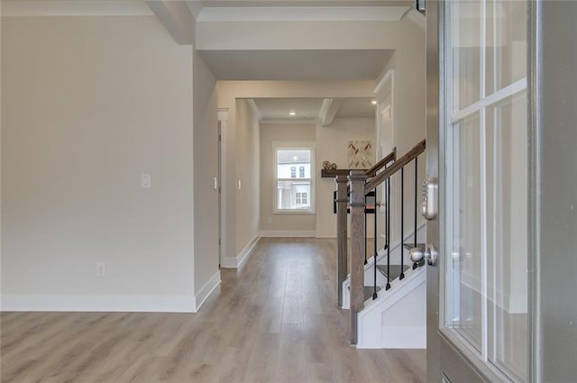 foyer entrance featuring stairway, crown molding, baseboards, and wood finished floors