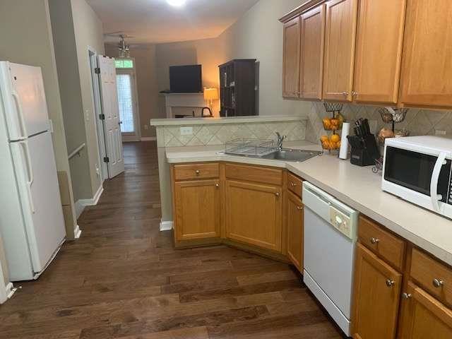 2253 Dillard Xing, Tucker, GA 30084 - kitchen with a sink, white appliances, a peninsula, tasteful backsplash, and dark wood-style flooring