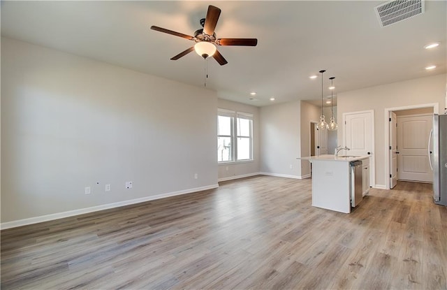 unfurnished living room with sink, ceiling fan with notable chandelier, and light hardwood / wood-style flooring