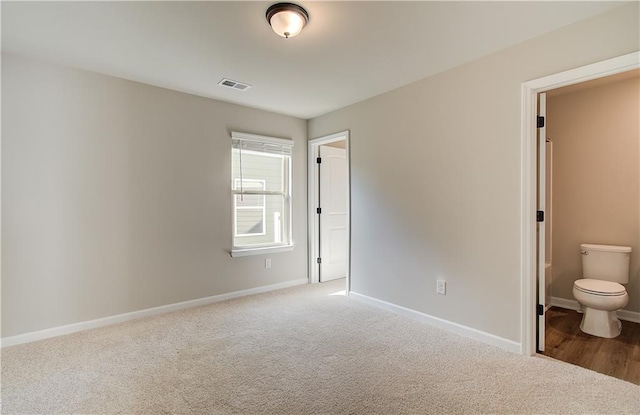 unfurnished bedroom with carpet and ensuite bathroom