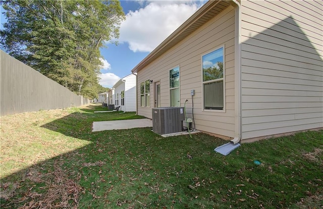 view of property exterior with a yard, cooling unit, and a patio area