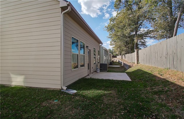 view of property exterior featuring central AC, a patio area, and a yard