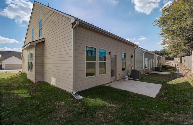 back of property featuring a patio, a yard, and central AC