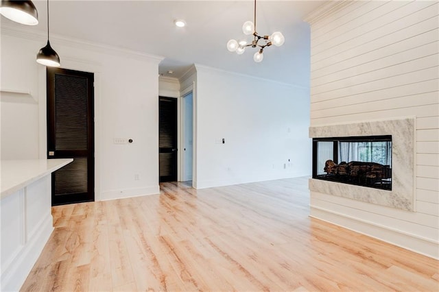 625 Piedmont Ave NE Unit 2004, Atlanta, GA 30308 - unfurnished living room featuring light wood-type flooring, crown molding, a chandelier, a multi sided fireplace, and recessed lighting