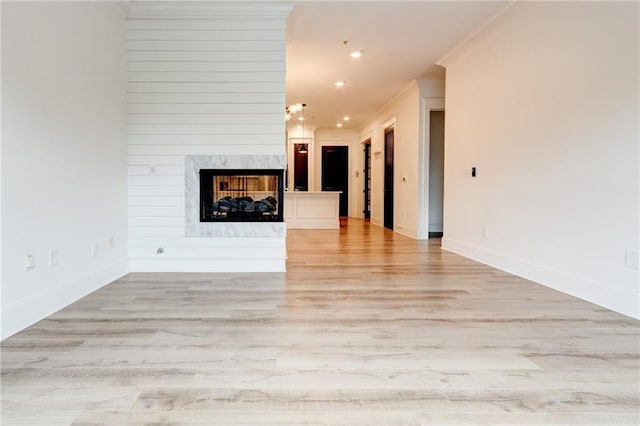 625 Piedmont Ave NE Unit 2004, Atlanta, GA 30308 - unfurnished living room with ornamental molding, light wood-style flooring, a high end fireplace, baseboards, and recessed lighting