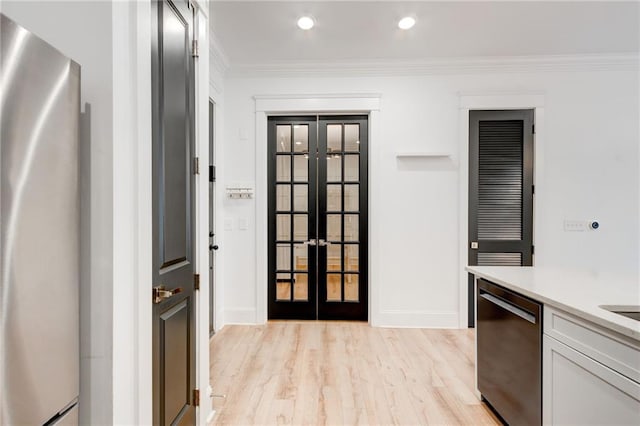 625 Piedmont Ave NE Unit 2004, Atlanta, GA 30308 - kitchen featuring french doors, appliances with stainless steel finishes, light countertops, crown molding, and light wood finished floors