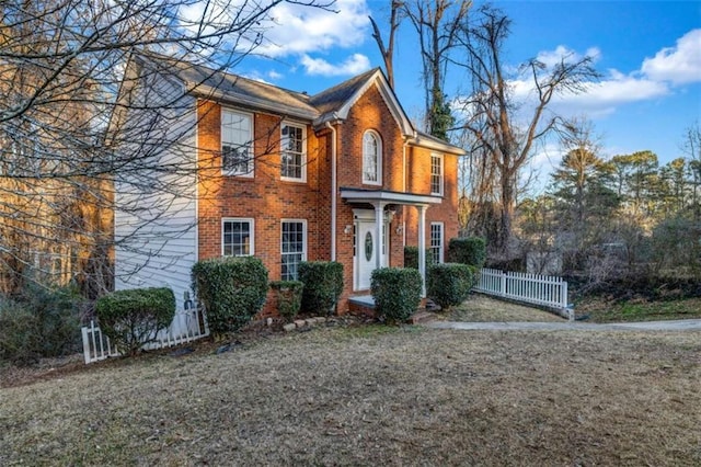 colonial house featuring a front lawn