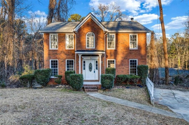 colonial inspired home featuring a front yard